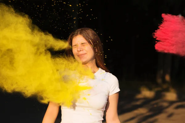 Alegre modelo joven con explosión de cele polvo amarillo y rosa — Foto de Stock