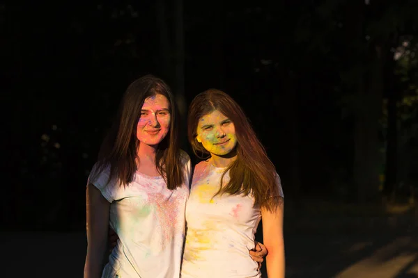 Dois amigos positivos se divertindo com pó Holi no parque — Fotografia de Stock