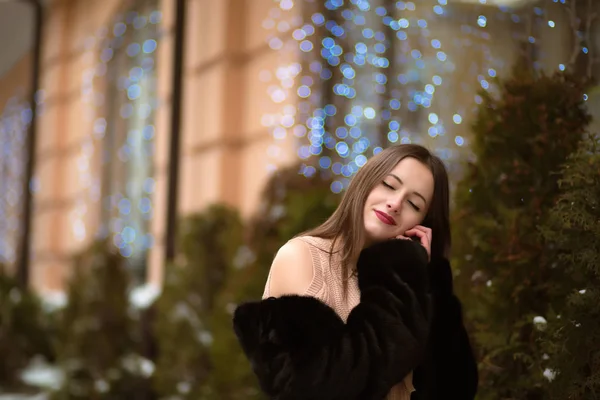 Inschrijving brunette vrouw dragen zwarte bontjas, poseren in de winkel — Stockfoto