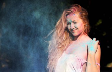 Kıvırcık saçlı mavi po bulutu içinde poz güzel sarışın kadın