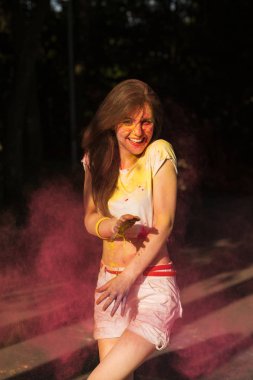 Neşeli genç model Pembe kuru boya Holi t bulutu poz