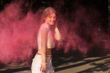 Holi pembe kuru boya patlayan ile oynarken oldukça esmer kadın