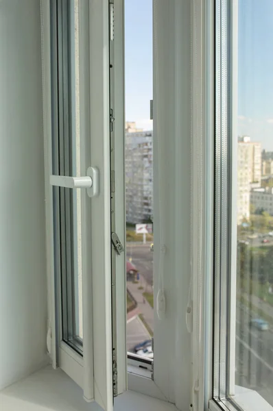 Open pvc window on the background of multi-storey apartment buil