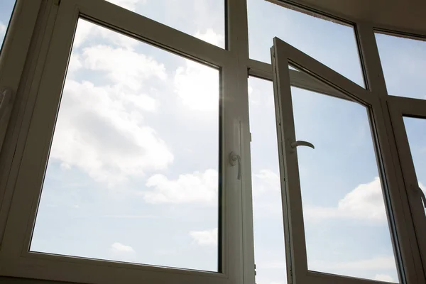 Open plastic window at the background of blue sky — Stock Photo, Image