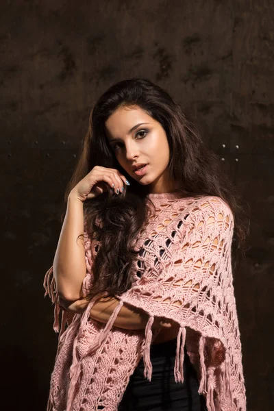 Beautiful tanned woman with long lush hair posing in pink sweate — Stock Photo, Image