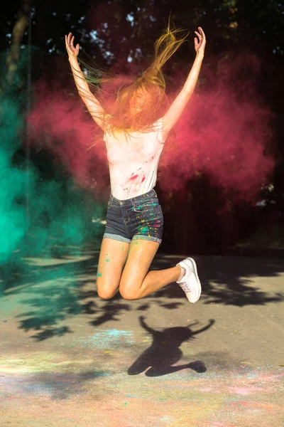 Mujer rubia positiva saltando con colores vibrantes explotando arou — Foto de Stock
