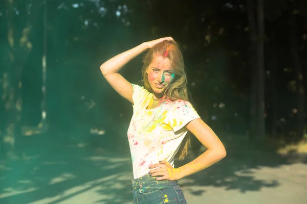 Bonita modelo loira brincando com tinta seca verde Holi no par — Fotografia de Stock