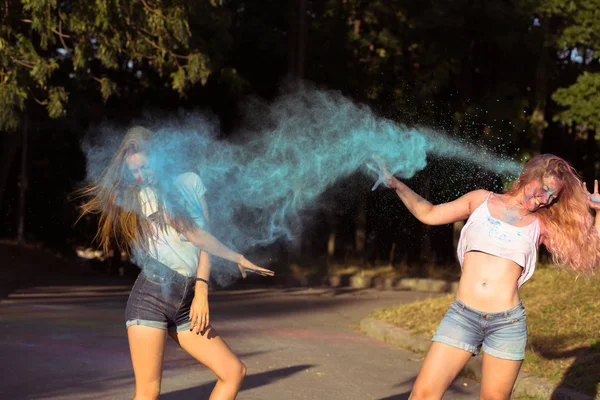 Zwei fröhliche blonde Freundinnen haben Spaß mit explodierendem Holi — Stockfoto