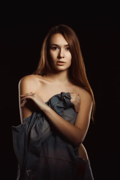 Verleidelijke jonge model met naakte schouders poseren in de donkere ro — Stockfoto