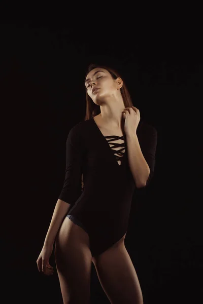 Сексуальная юная леди в черном нижнем белье позирует в тени — стоковое фото