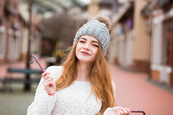 Adorable red haired woman in trendy apparel holding tasty Christ — Stock Photo, Image