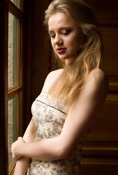 Елегантна блондинка з довгим волоссям одягнена в сукню з голим взуттям — стокове фото