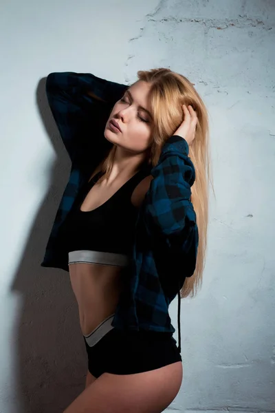 Sexig ung kvinna i sport underkläder poserar i studio med skugga — Stockfoto