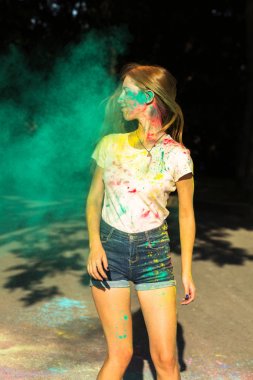 Yeşil kuru boya Holi p ile oynarken çok güzel sarışın kadın