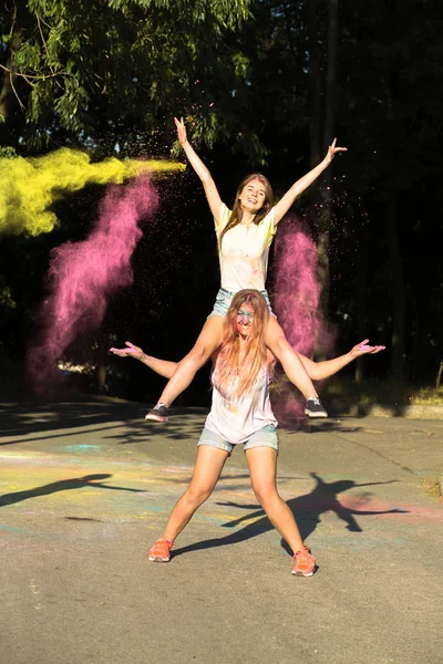 Holi po patlayan ile eğleniyor iki mutlu sarışın kadın arkadaş — Stok fotoğraf