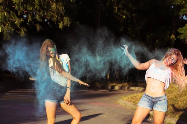 Zwei lustige junge Freundinnen haben Spaß mit explodierendem Holi Pow — Stockfoto