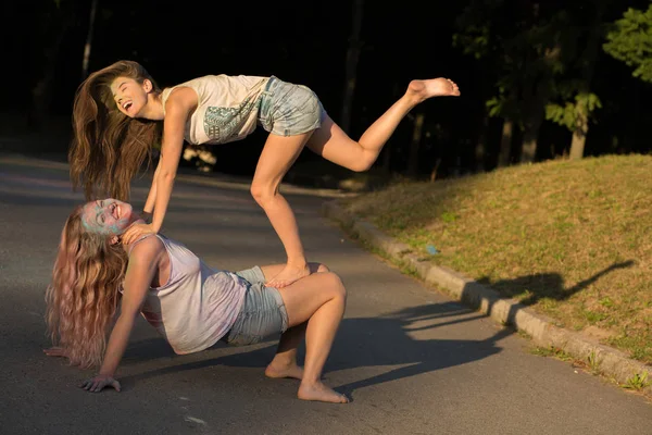 Duas mulheres amigas rindo cobertas com tinta colofrul tendo fu — Fotografia de Stock