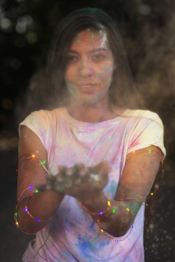 Harika tabaklanmış Asya modeli w poz Holi boya ile eğleniyor