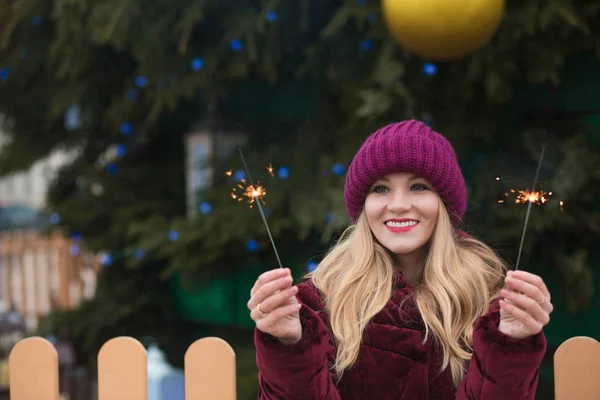Awesome blonde woman having fun with sparkling bengal lights at — Stock Photo, Image