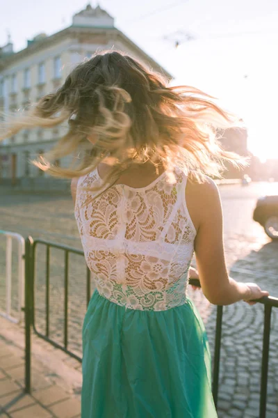 Hermosa chica rubia con el pelo revoloteando posando en los rayos del sol en — Foto de Stock