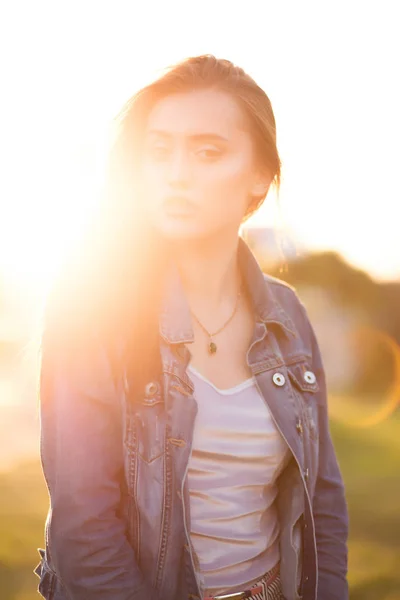 Mulher morena glamourosa posando ao pôr do sol com brilho do sol — Fotografia de Stock