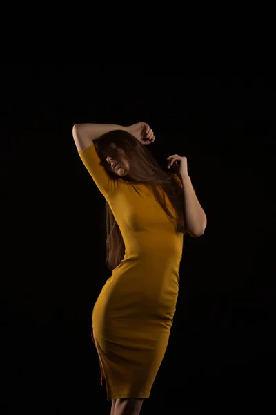 Mujer morena seductora con el pelo largo posando en vestido amarillo a —  Fotos de Stock