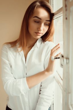Güzel esmer Bayan beyaz gömlek ayakta, closeup çekim 