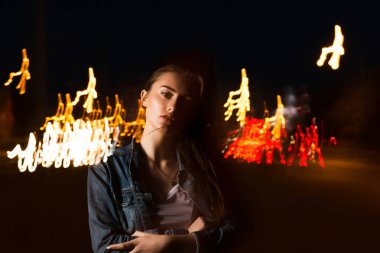 Güzel genç kadın, cadde t olarak karışık ışığıyla poz