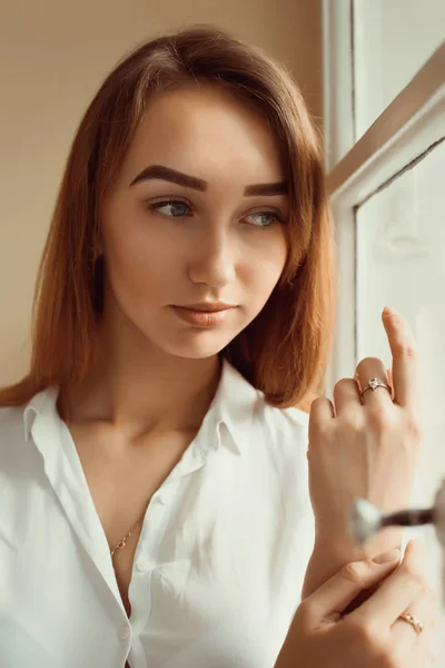 Close-up shot van prachtige brunette vrouw in wit overhemd staande — Stockfoto