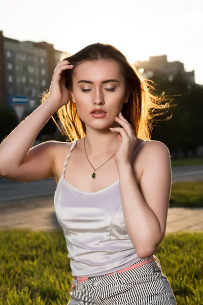 Prachtige jonge vrouw met perfecte make-up poseren in de stralen van de zon een — Stockfoto