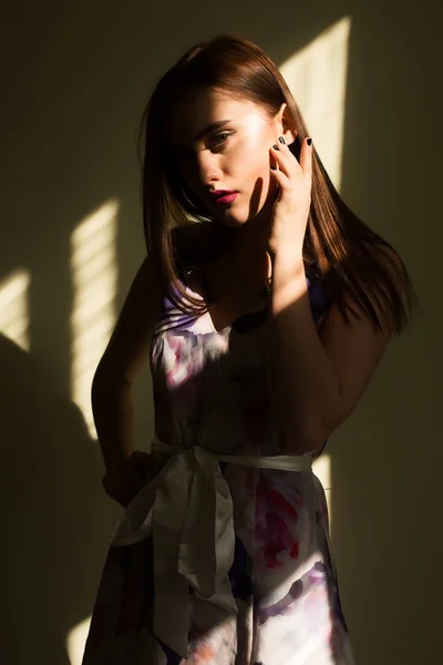 Гламурна молода жінка з яскравим макіяжем позує в темній кімнаті з s — стокове фото