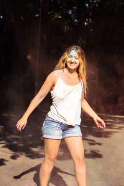 Uzun kıvırcık saçlı Holi fes kutluyor duygusal sarışın model