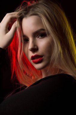 Güzel genç bir bayanla parlak makyaj ve uzun dalgalı saç poz