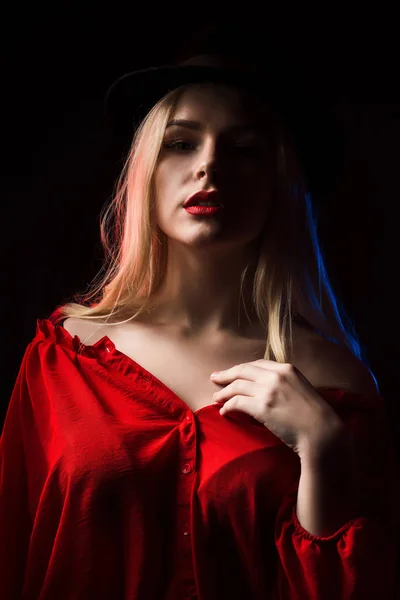Sexy mladá žena nosí červené halence a klobouk pózuje ve stínu — Stock fotografie