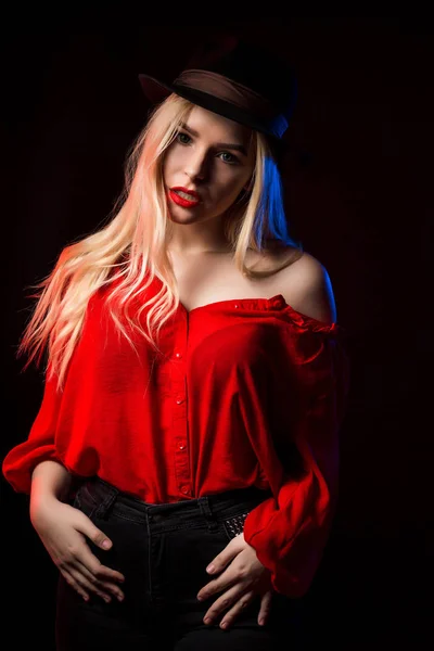 Gyönyörű fiatal nő visel piros blúz és kalapban pózol a s — Stock Fotó