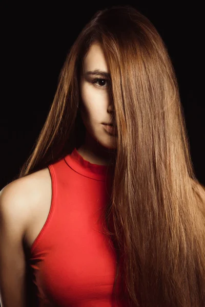 Modne młoda kobieta z długo lśniące włosy pozowanie na czarny — Zdjęcie stockowe