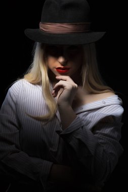 İle poz şapka ve beyaz bluz giyen gizemli genç kadın 