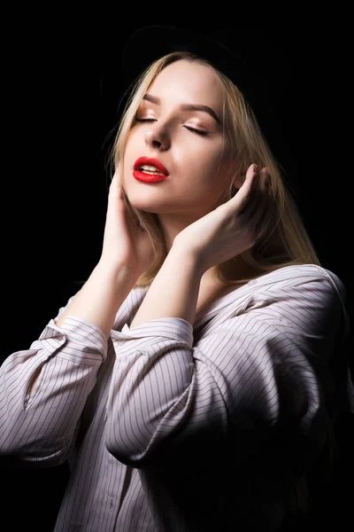 Mujer rubia tierna con blusa blanca, posando en la oscuridad en — Foto de Stock