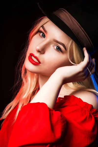 Чудова молода жінка в червоній блузці і капелюсі позує в шкурі — стокове фото