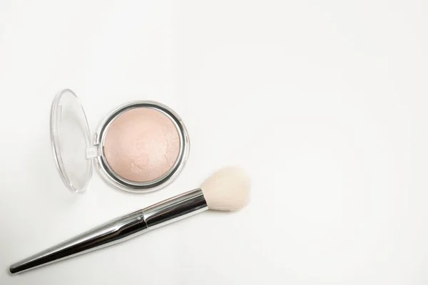 Closeup shot of pearl highlighter with cosmetic brush on a white — Stock Photo, Image
