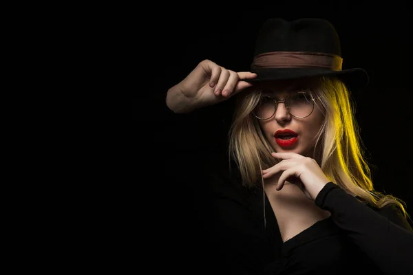 Okouzlující mladá žena nosí černou halenku, klobouk a brýle, polohy — Stock fotografie