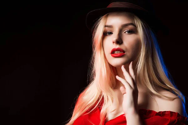 Charmante jonge vrouw in rode blouse en bruin hoed poseren in studi — Stockfoto