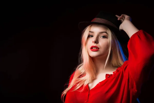 Jovem elegante em blusa vermelha e chapéu marrom posando no estúdio — Fotografia de Stock