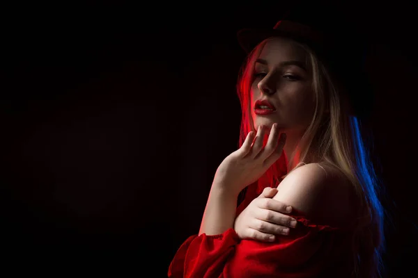 Verleidelijke jonge vrouw in rode blouse en bruin hoed poseren bij stud — Stockfoto