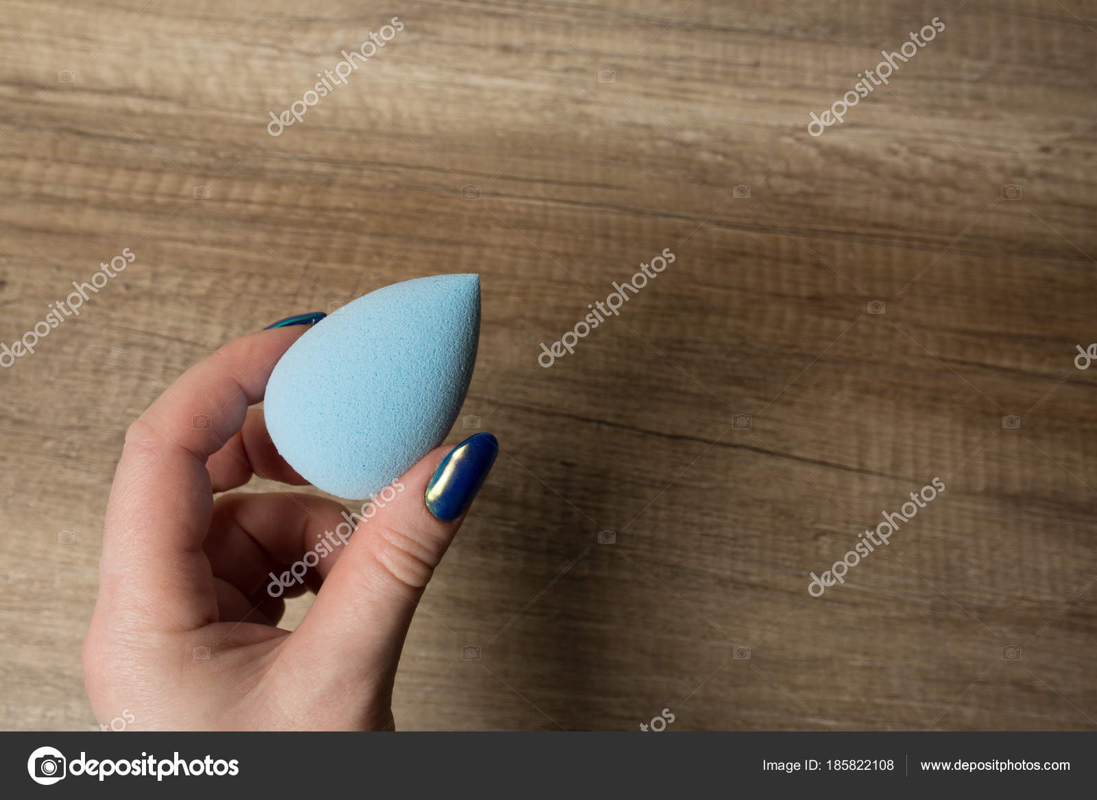 Female Hand Holding Blue Beauty Sponge Over A Wood Background Stock Photo C Vika Pavlyuk 185822108