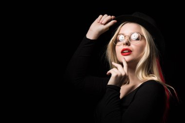 Posin şaşırtıcı genç kadın siyah bluz, şapka ve gözlük,