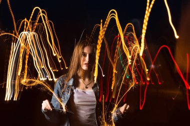Gece av bengal ışıkları ile poz güzel genç kadın