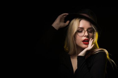 Giyen siyah bluz, şapka ve gözlük, posi muhteşem genç kadın