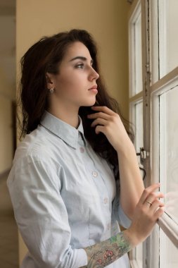 Muhteşem genç kadın kıvırcık saçlı ve onun kol pos bir dövme