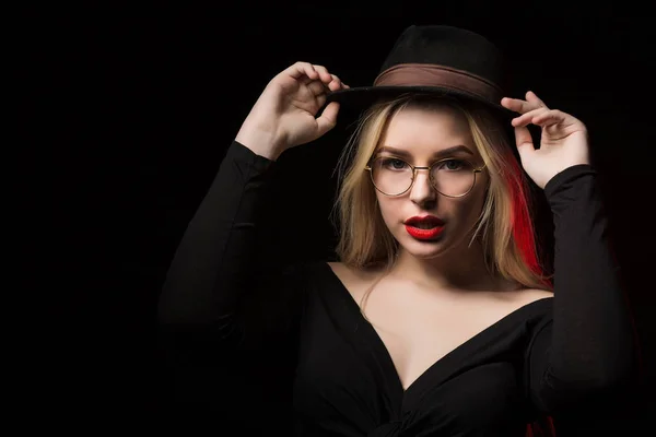 Entzückende junge Frau mit schwarzer Bluse, Hut und Brille, — Stockfoto